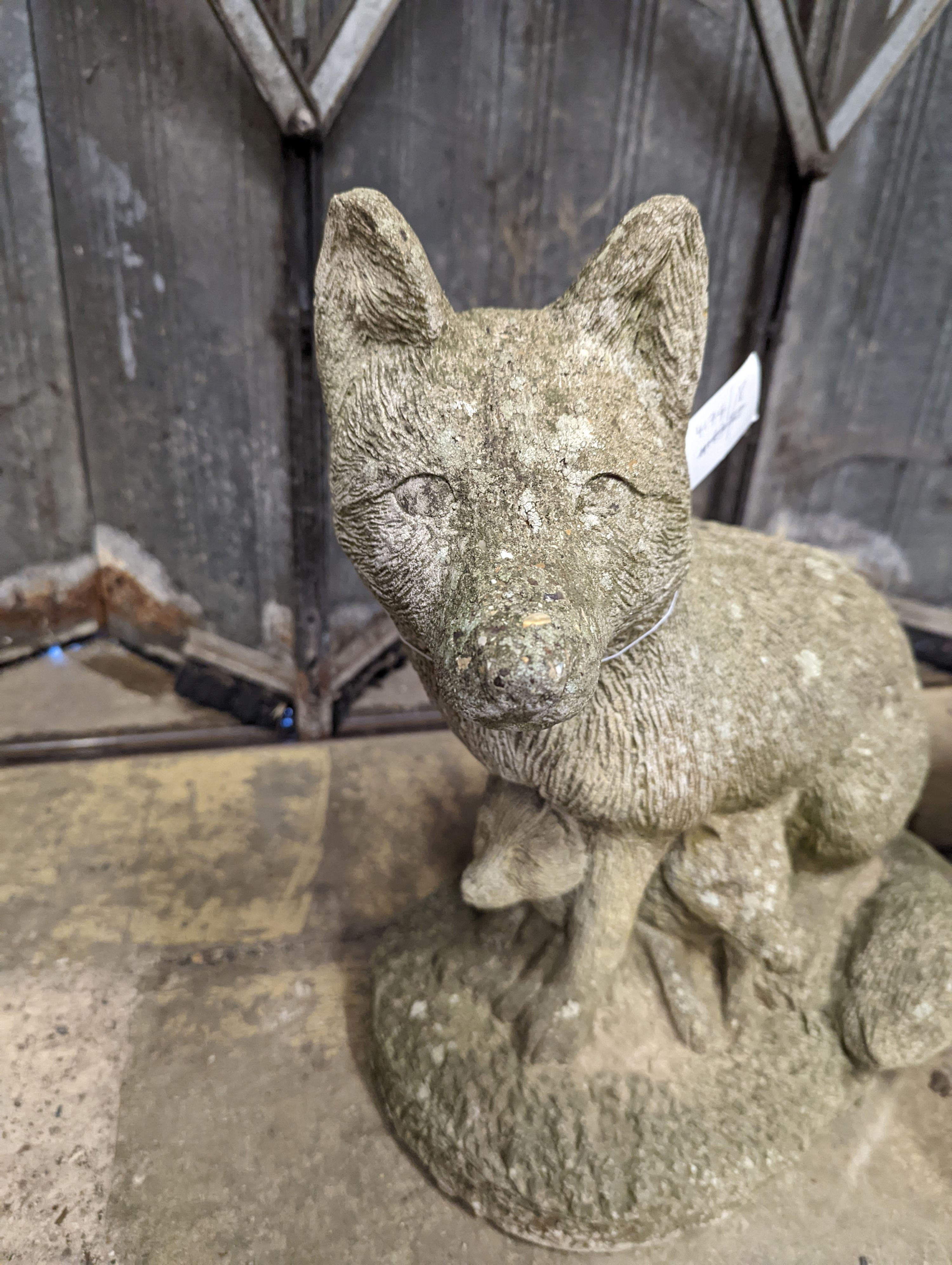 A reconstituted stone garden ornament modelled as a fox with cub, height 42cm